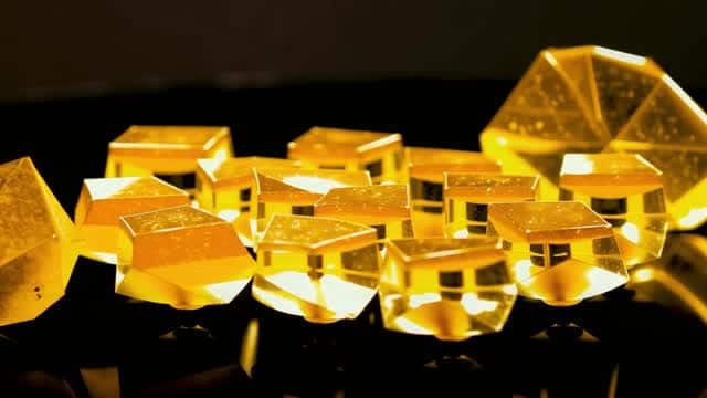 Shining golden quartz crystals on dark reflective surface AI video preview