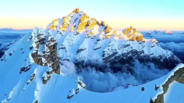 雪に覆われた高山の峰に昇るドラマチックな朝日 AI video preview