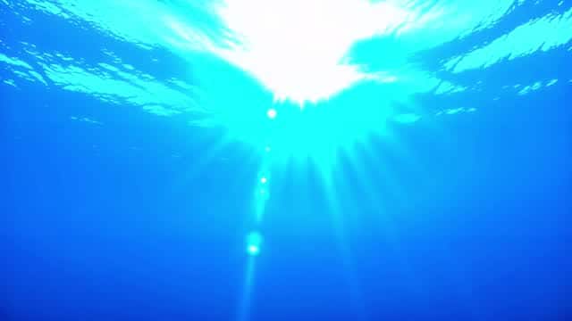 Underwater view of sunlight penetrating clear blue water AI video preview