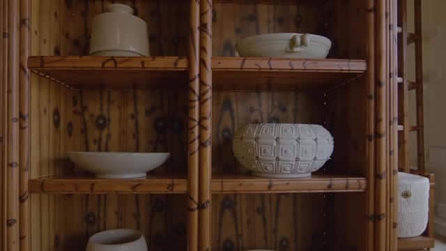 Wooden shelving unit displaying ceramic bowls and pottery AI video preview