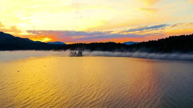 Misty sunrise view of mountains over tranquil water AI video preview
