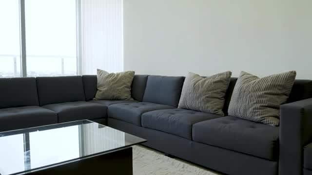 Bright modern living room interior space with large sectional sofa AI video preview